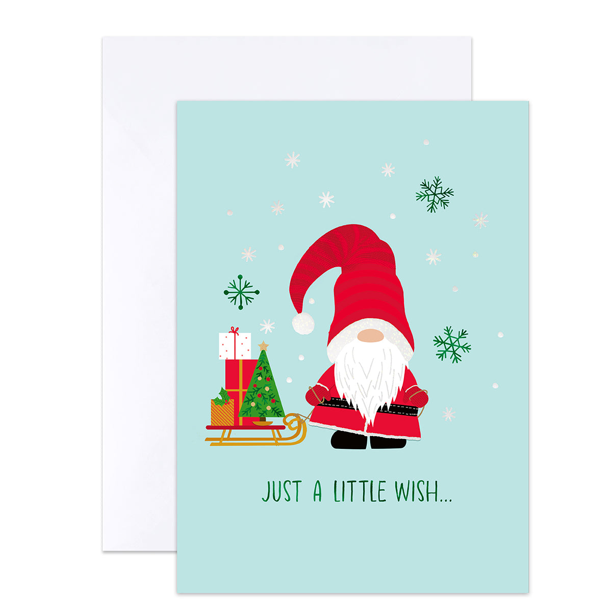 A Christmas greeting card with a light blue background, featuring a cartoon gnome in a red hat and coat beside a sleigh with wrapped gifts and a small tree. The card reads 'JUST A LITTLE WISH.