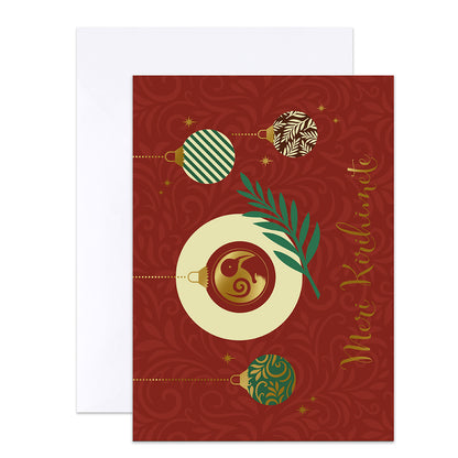 A red Christmas greeting card with gold decorative swirls, illustrated hanging ornaments, a green leaf, and gold cursive text reading 'Merry Christmas,' shown with a white envelope behind it on a white background.