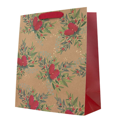 A brown kraft paper gift bag with a red handle, decorated with a green and red holly leaf pattern, and featuring a solid red inner side and base, shown on a white background.