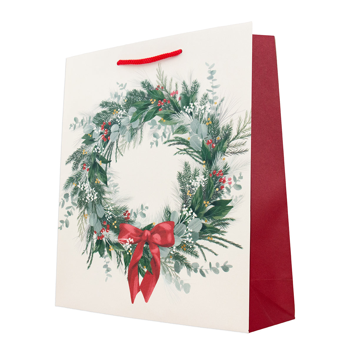 A cream-colored paper gift bag with a red rope handle, featuring a large printed Christmas wreath design with green foliage, red berries, and a red bow, with a solid red inner panel visible on the right side.