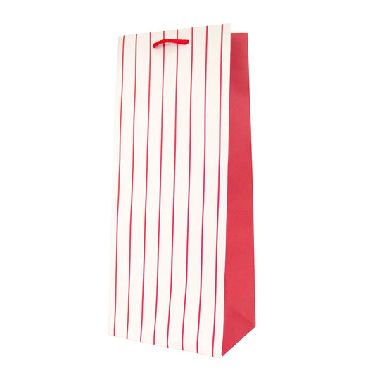 A tall paper gift bag with vertical red stripes on a white front panel, a solid red side panel, and a red paper handle, shown on a plain white background.
