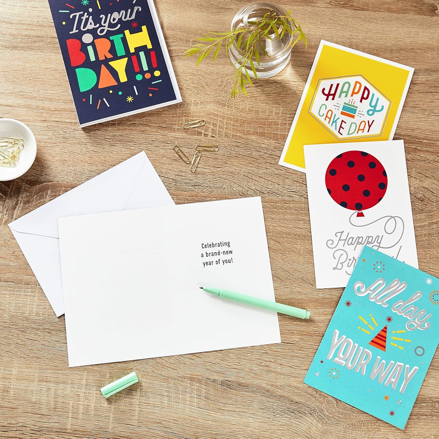 Hallmark Birthday Cards Assortment, Happy Cake Day (12 Cards with Envelopes) flat lay of colourful cards on wooden table with envelopes.