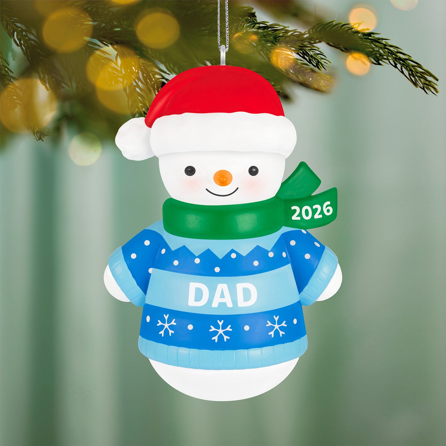 Dad Snowman 2026 — 2026 Hallmark Keepsake Christmas Ornament, smiling snowman in a blue sweater with red hat and green scarf, close up view.