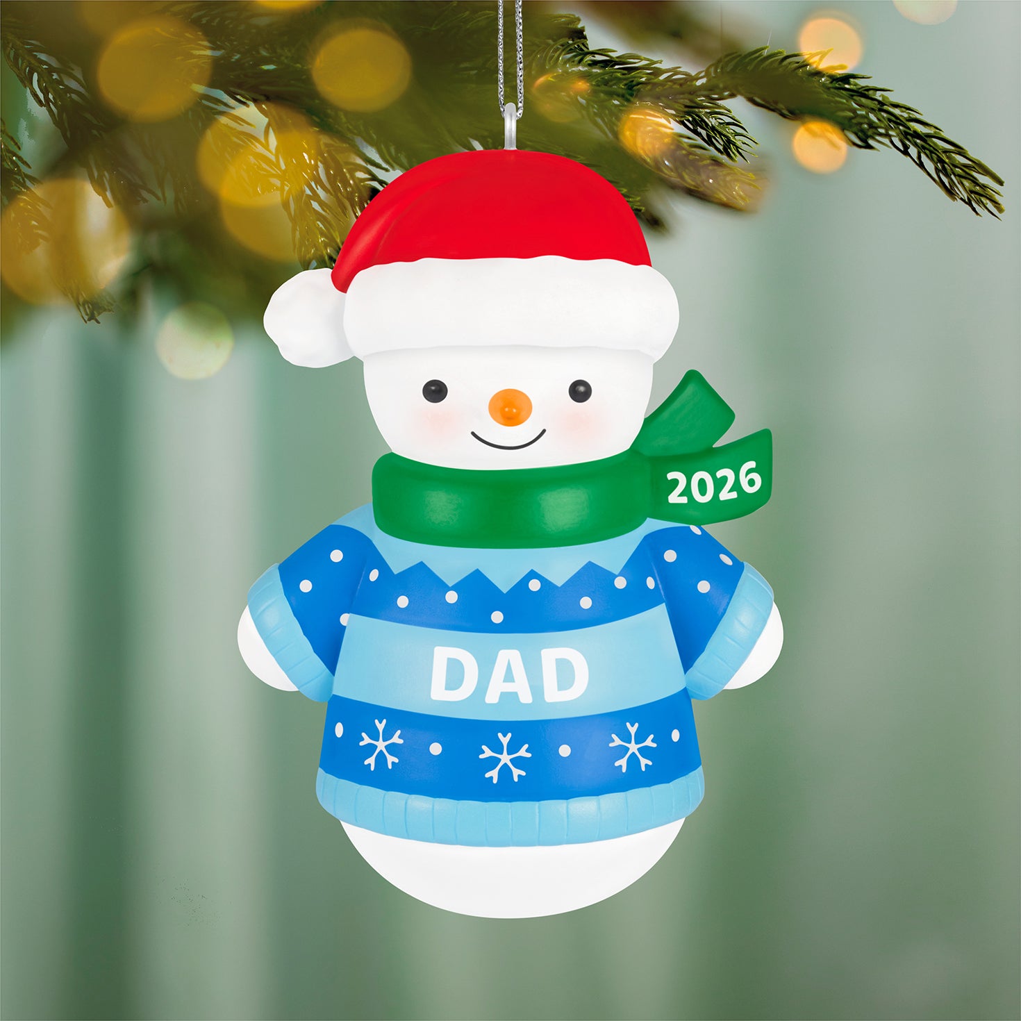 Dad Snowman 2026 — 2026 Hallmark Keepsake Christmas Ornament, smiling snowman in a blue sweater with red hat and green scarf, close up view.