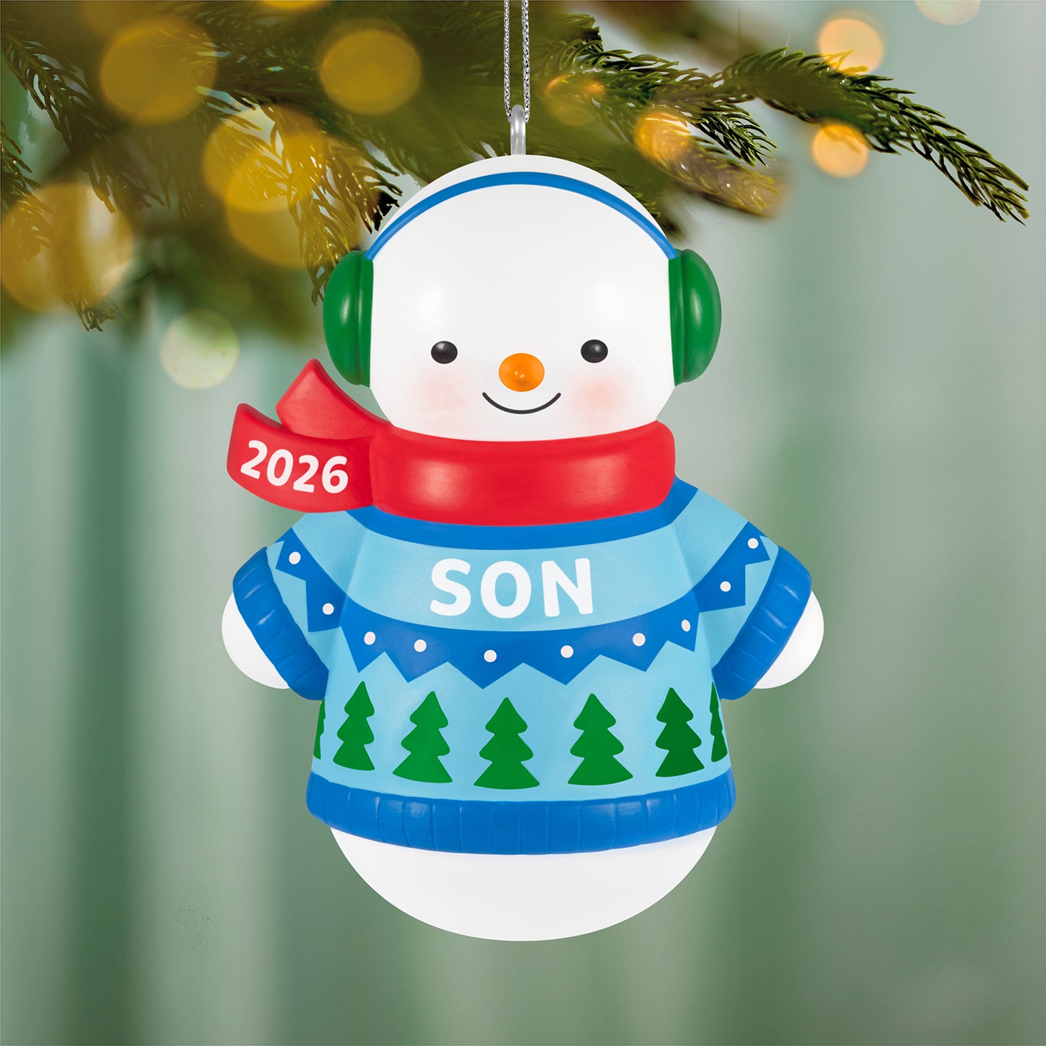 Son Snowman 2026 — 2026 Hallmark Keepsake Christmas Ornament featuring a smiling snow-boy in a blue sweater with a red scarf, hanging on a tree.