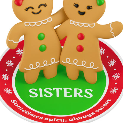 Sweet and Spicy Sisters — 2026 Hallmark Keepsake Christmas Ornament featuring whimsical gingerbread girls with buttons standing on a festive rug.