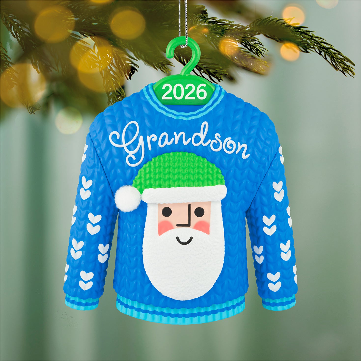 Grandson Santa Sweater 2026 — 2026 Hallmark Keepsake Christmas Ornament featuring a blue jumper with a Santa face and white hearts, close up view.