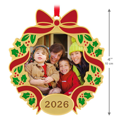 Our Family Christmas 2026 photo frame, metal, features a gold wreath design with holly, showcasing a family photo.