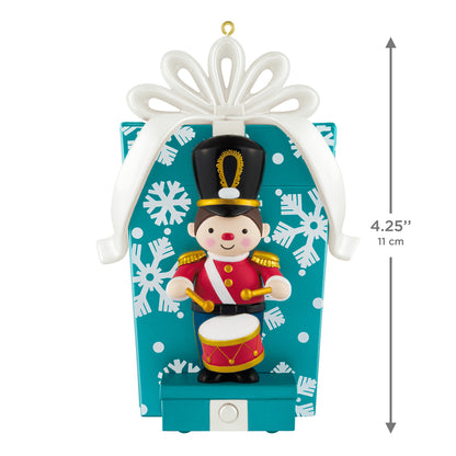 Toy Soldier Musical With Motion — 2026 Hallmark Keepsake Christmas Ornament sitting in front of a blue gift box with snowflakes.