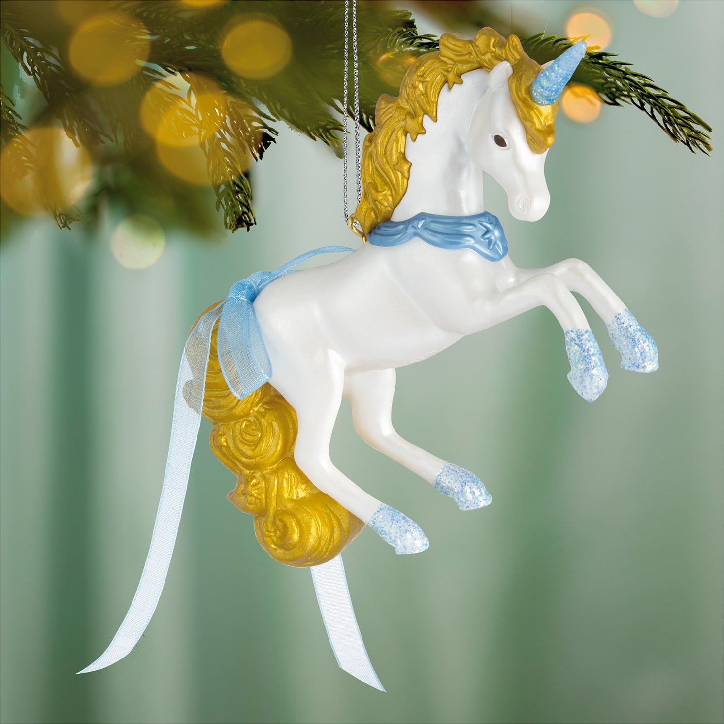 Celestial Unicorn — 2026 Hallmark Keepsake Christmas Ornament, white and gold with glittery details, hanging on a tree branch.