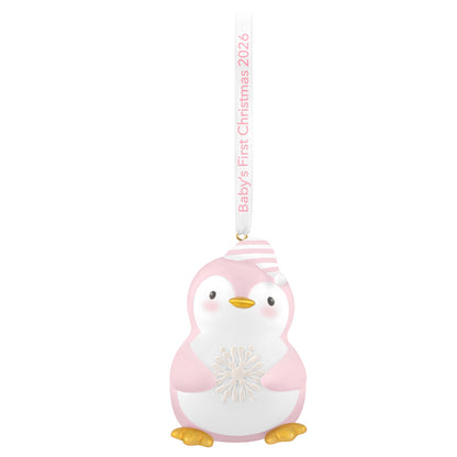 Baby girl's first Christmas penguin 2026 ornament, pink and white, featuring a snowflake and striped cap, hung with a ribbon.