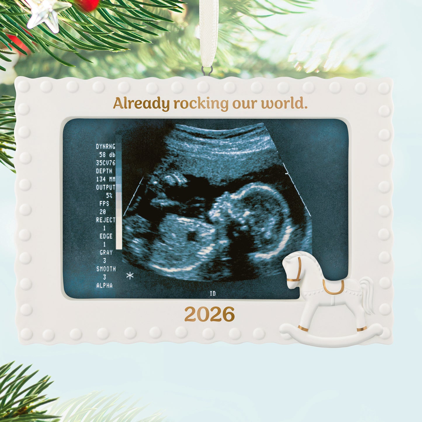 Already Rocking Our World 2026 photo frame, porcelain with sonogram holder and rocking horse design, displayed on a Christmas tree.