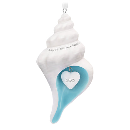 Forever in Our Hearts Shell 2026, porcelain Christmas ornament in a conch shell design with blue interior and year-dated heart charm.