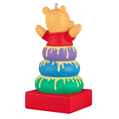 Disney Winnie the Pooh Baby's First Christmas 2026 — 2026 Hallmark Keepsake Christmas Ornament features Winnie the Pooh atop colourful stacking rings, detailed with honey.