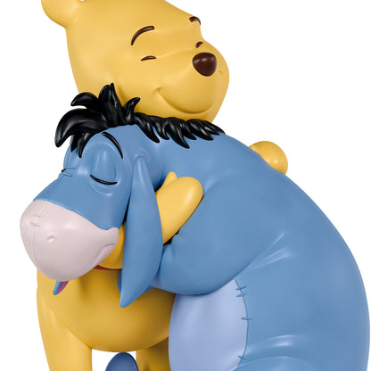 Disney Winnie the Pooh Holiday Hugs — 2026 Hallmark Keepsake Christmas Ornament featuring Pooh Bear and Eeyore in a warm embrace, close-up view.