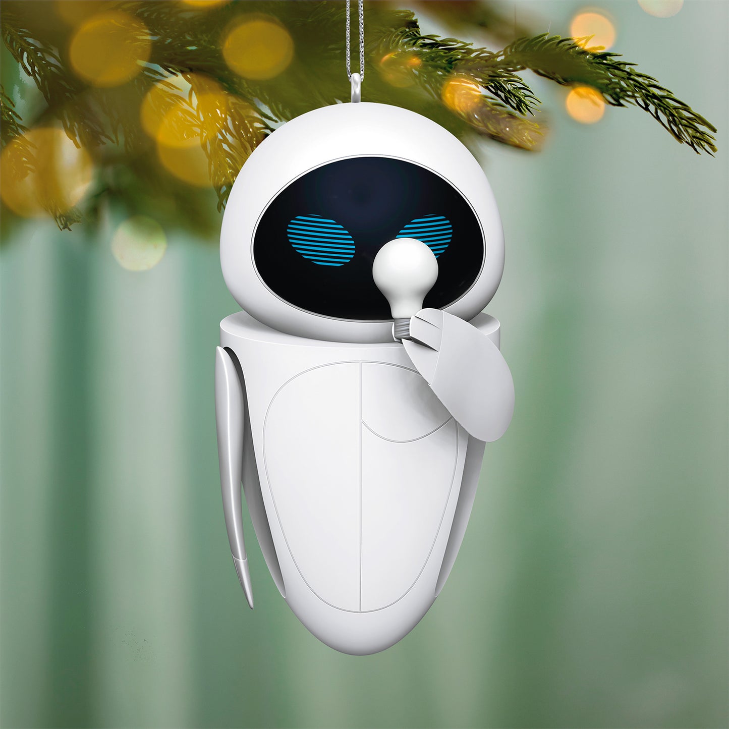 Disney/Pixar Wall-E Eve — 2026 Hallmark Keepsake Christmas Ornament, white and black droid hanging on a Christmas tree, soft bokeh background.