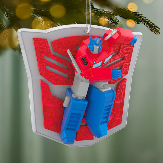 Hasbro Transformers Optimus Prime's Power — 2026 Hallmark Keepsake Christmas Ornament featuring Optimus Prime in action pose against a vibrant shield backdrop.