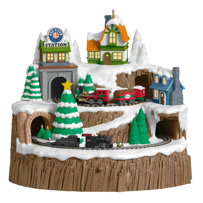 Lionel Christmas Mountain Musical With Light and Motion — 2026 Hallmark Keepsake Christmas Ornament featuring a snowy mountain scene with a train station and trees.