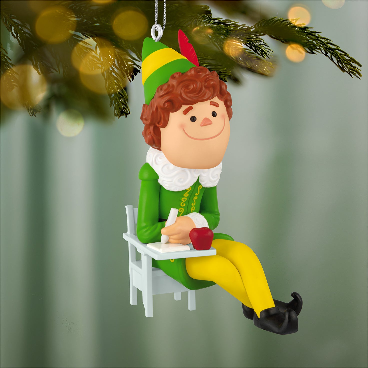 Elf Buddy the Elf — 2026 Hallmark Keepsake Christmas Ornament, colourful figurine seated at a desk with an apple, focused expression
