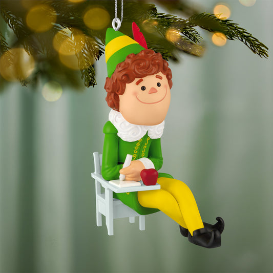 Elf Buddy the Elf — 2026 Hallmark Keepsake Christmas Ornament, colourful figurine seated at a desk with an apple, focused expression