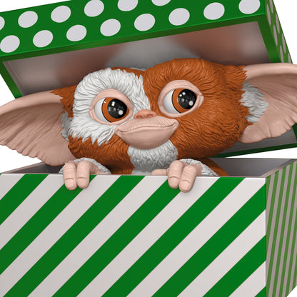 Gremlins Gizmo — 2026 Hallmark Keepsake Christmas Ornament, cute Mogwai figure peeking from festive package with green stripes.