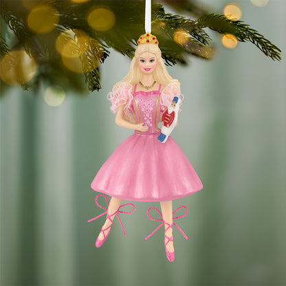 Barbie™ in the Nutcracker 25th Anniversary, porcelain and fabric ornament, featuring Barbie in a pink dress holding a toy, hanging on a tree.