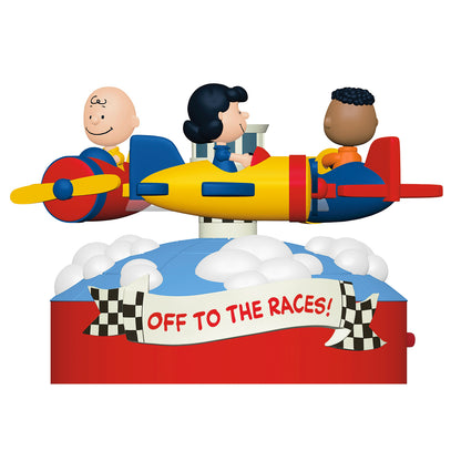 The Peanuts® Gang Off to the Races! Musical With Motion — 2026 Hallmark Keepsake Christmas Ornament featuring Charlie Brown, Lucy, and Franklin in colourful planes, set against a decorative base.