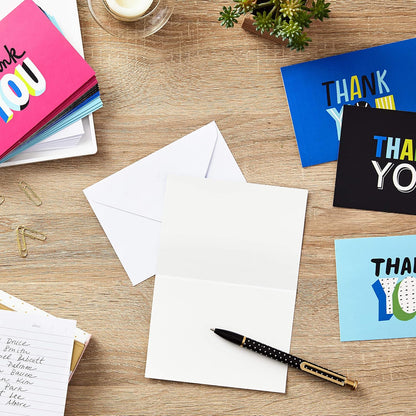 Hallmark Thank You Cards Assortment, Colorful Thanks (48 Cards with Envelopes) for Graduation, Birthday, Bridal Showers and More, flat lay showing varied card designs and envelopes on a wooden surface.