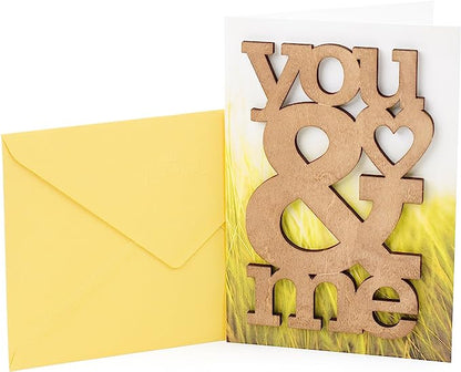 Hallmark Signature Anniversary Greeting Card (Wooden You & Me) with wooden cutout on grassy background beside yellow envelope