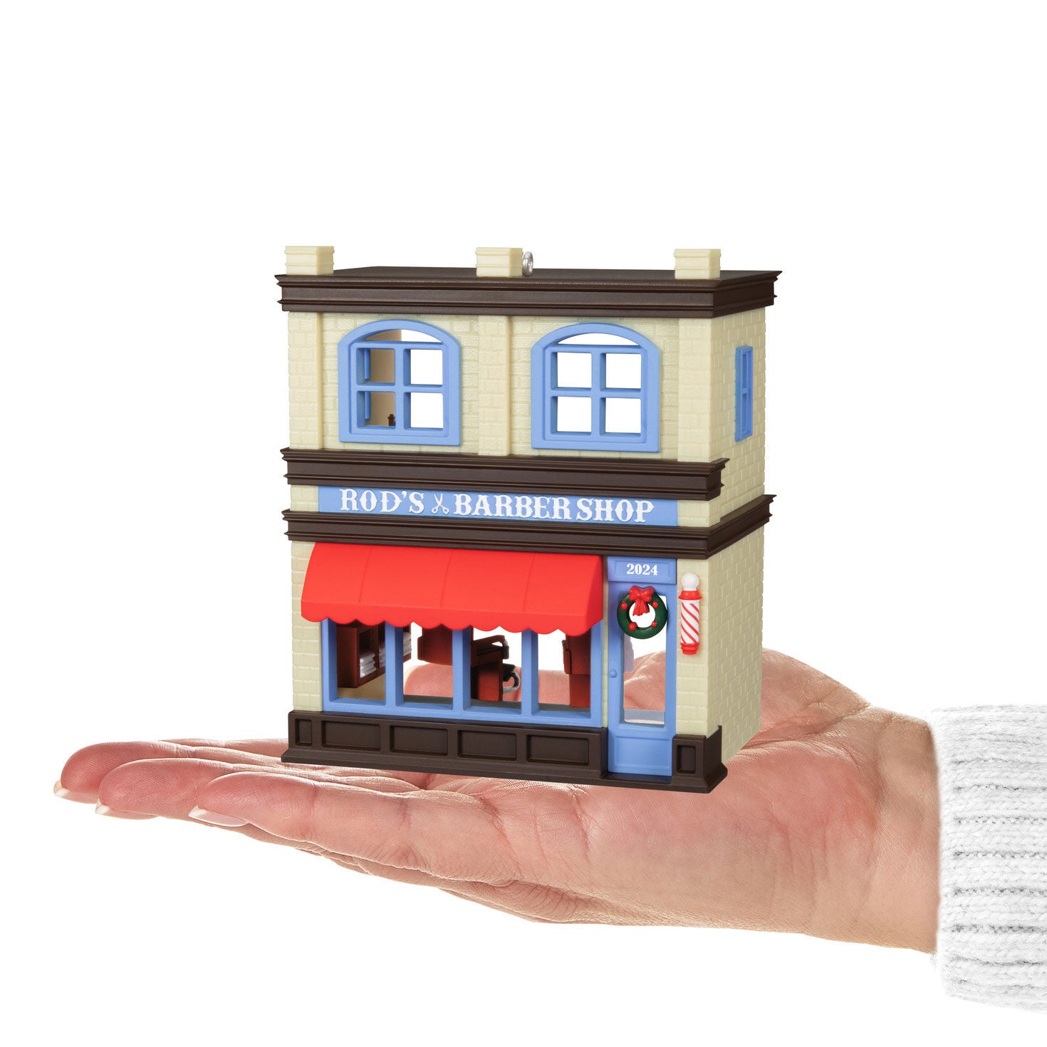 Nostalgic Houses and Shops Rod's Barbershop — Hallmark Keepsake Christmas Ornament held in hand, detailed shop front with wreath and red awning.
