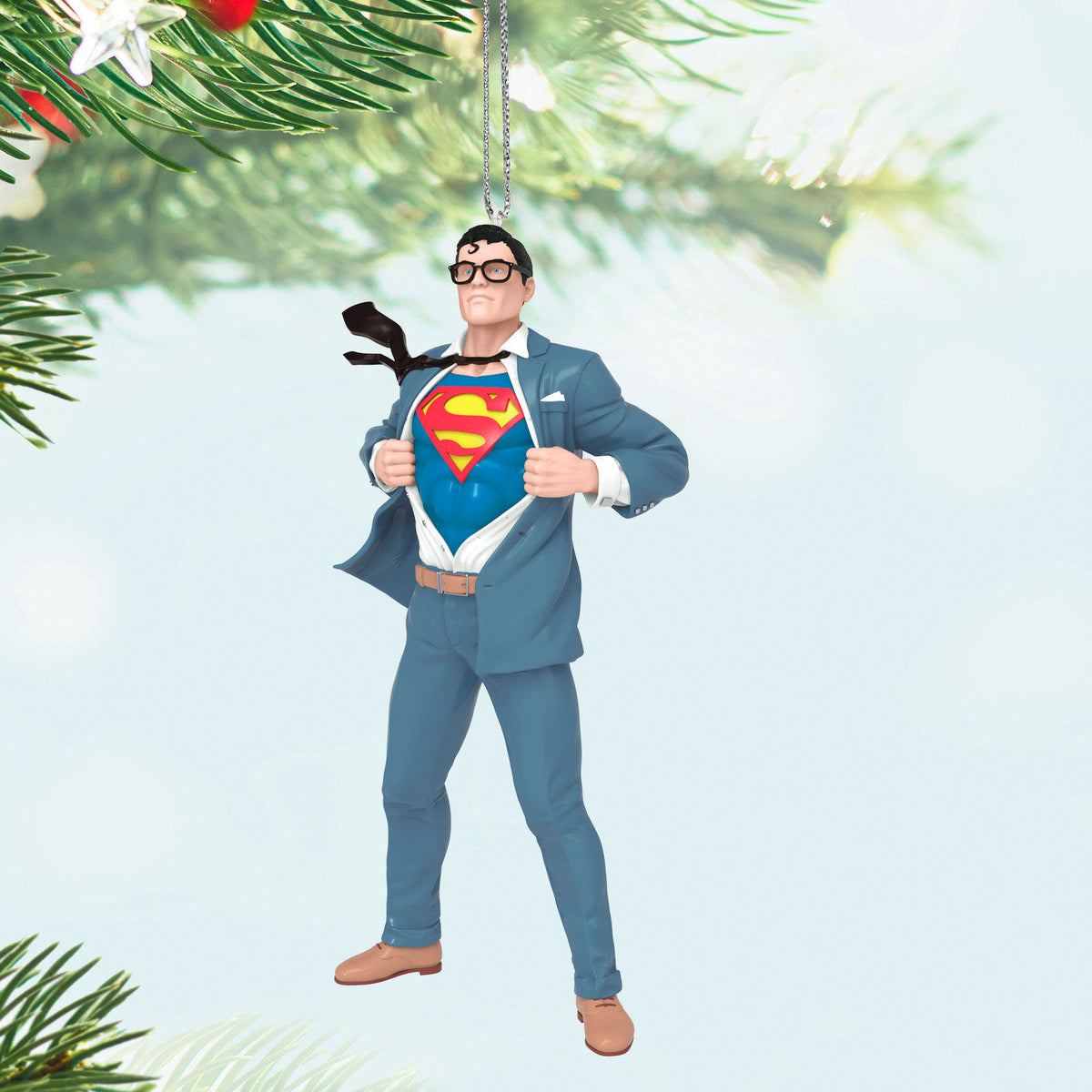 DC™ Superman™ Clark Kent™ — Hallmark Keepsake Christmas ornament in blue suit revealing S-Shield; detailed action figure against holiday backdrop.