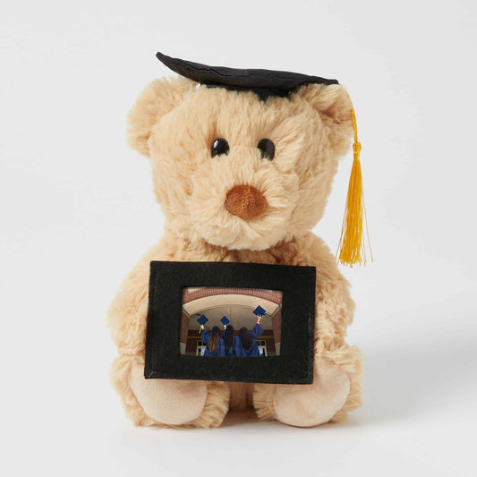 Graduation Notting Hill Bear in a graduation cap holding a small photo frame, showcasing a cherished memory.