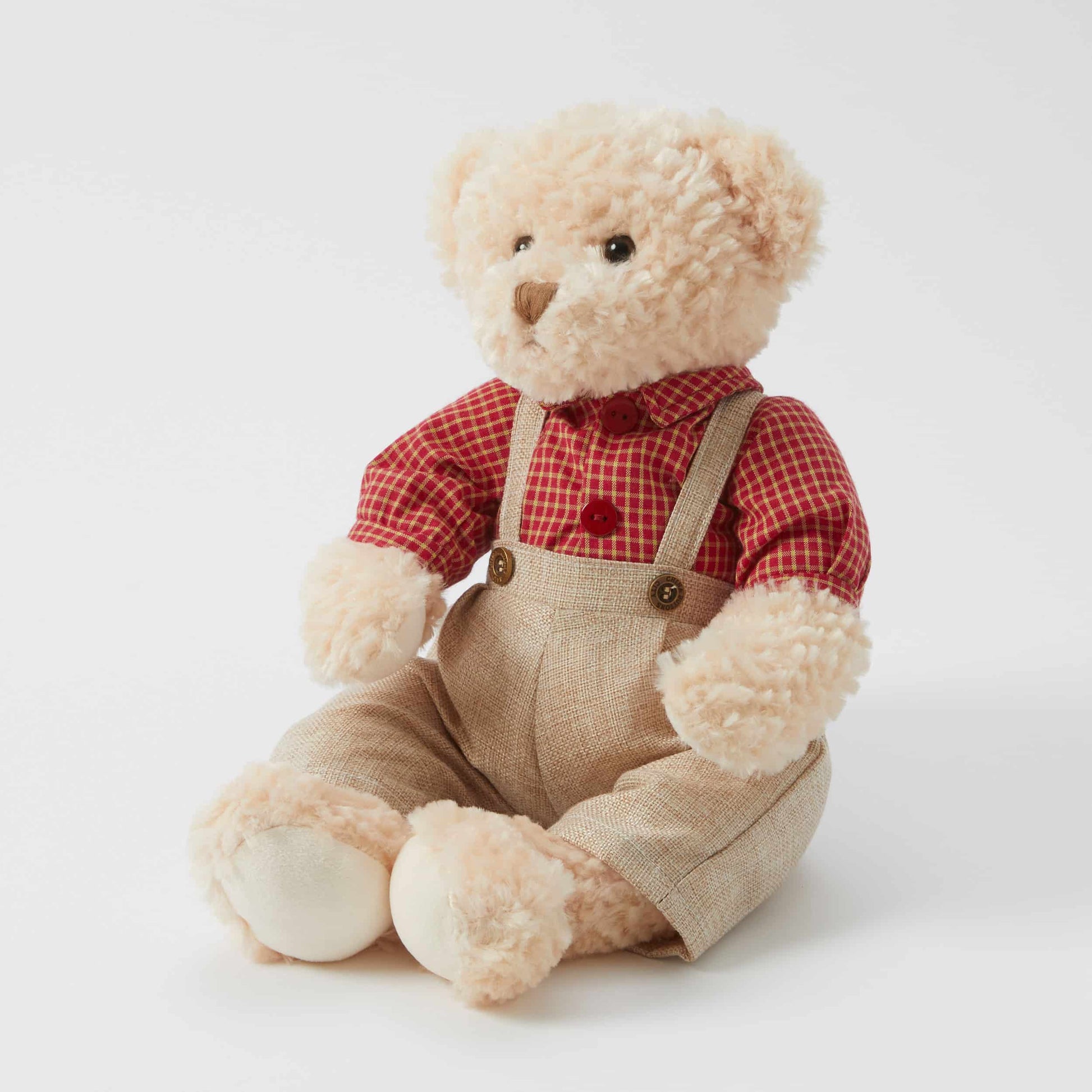 Edward the Notting Hill Bear in a red plaid shirt and beige overalls, sitting pose for display.
