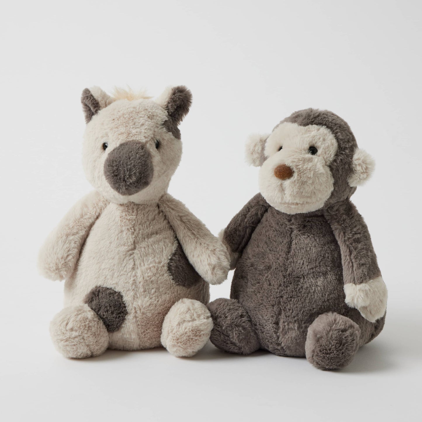 Jojo the Monkey - Plush Toy alongside a soft beige animal plush, featuring an appealing cuddle-ready design and unique textures.