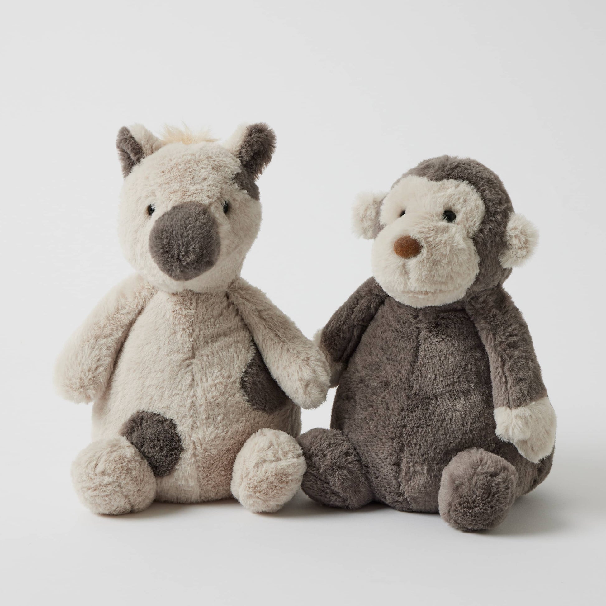 Jojo the Monkey - Plush Toy alongside a soft beige animal plush, featuring an appealing cuddle-ready design and unique textures.