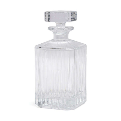 Whisky decanter made from clear glass with vertical ribbing design and a simple square stopper, side view.