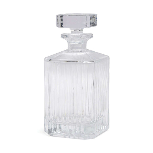 Whisky decanter made from clear glass with vertical ribbing design and a simple square stopper, side view.
