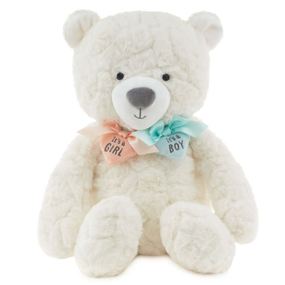 Gender reveal teddy bear plush with ribbons, white fur, featuring pink and blue heart charms around its neck in a front view.