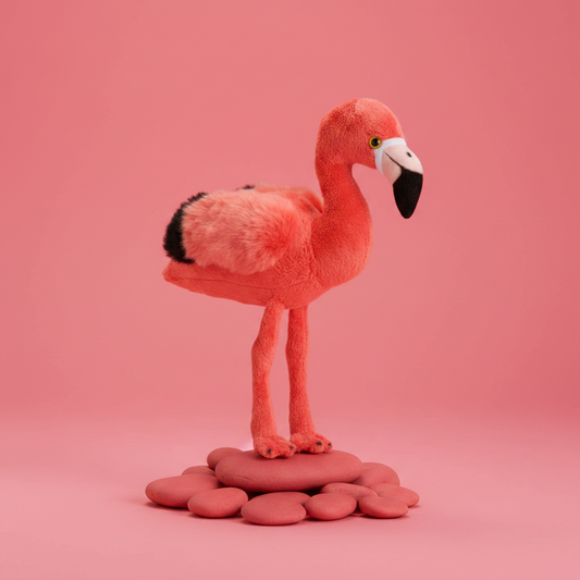 Plush flamingo toy on a pink background