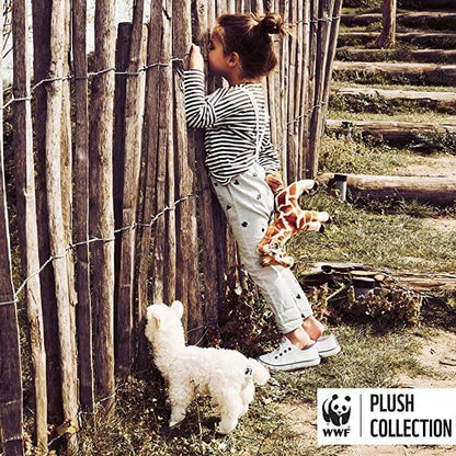 WWF Alpaca White - 31 cm - 12" plush toy beside a child exploring a fence, soft and cuddly design in outdoor setting.