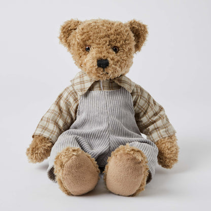 Chester the Notting Hill Bear in grey corduroy overalls and check shirt, seated view showcasing plush faux fur texture.