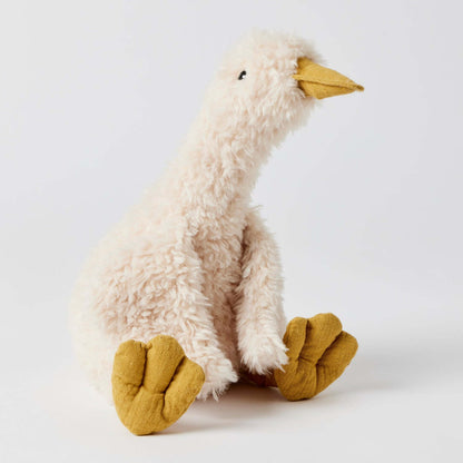 Wiggles the Duck plush toy in cream with yellow feet, sitting pose highlighting its soft texture and playful design.