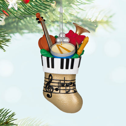 Stocking Stuffers — Hallmark Keepsake Christmas Ornament, festive gold stocking filled with musical instruments, close up view.