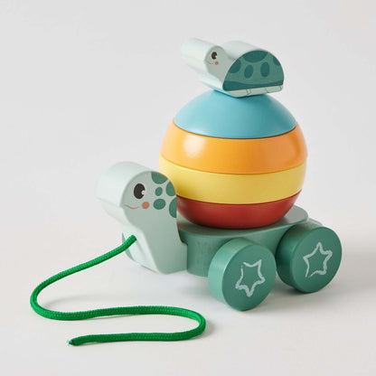 Pull along stacking turtle toy made from wood, featuring colourful stacking rings and a green pull string, angled view.