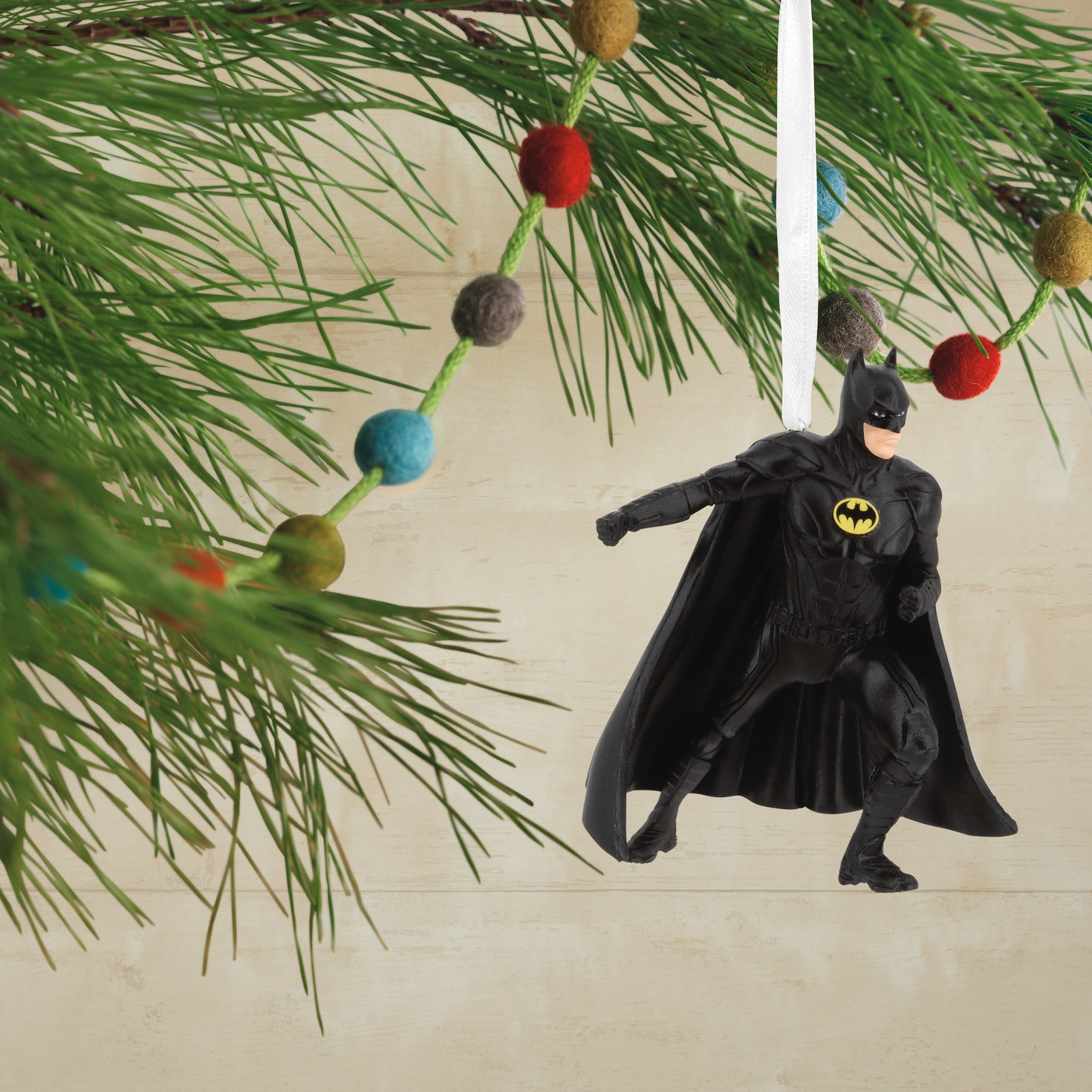 Hallmark Christmas Ornament - DC The Flash Batman; detailed view of Batman ornament hanging from a pine branch.