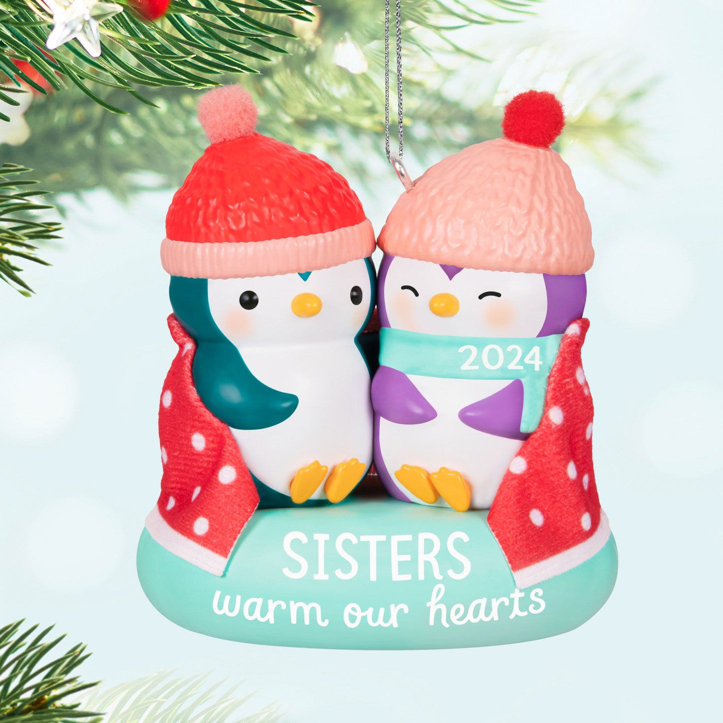 Sisters warm our hearts — Hallmark Keepsake Christmas ornament featuring two penguins in hats, wrapped in a blanket, 2024