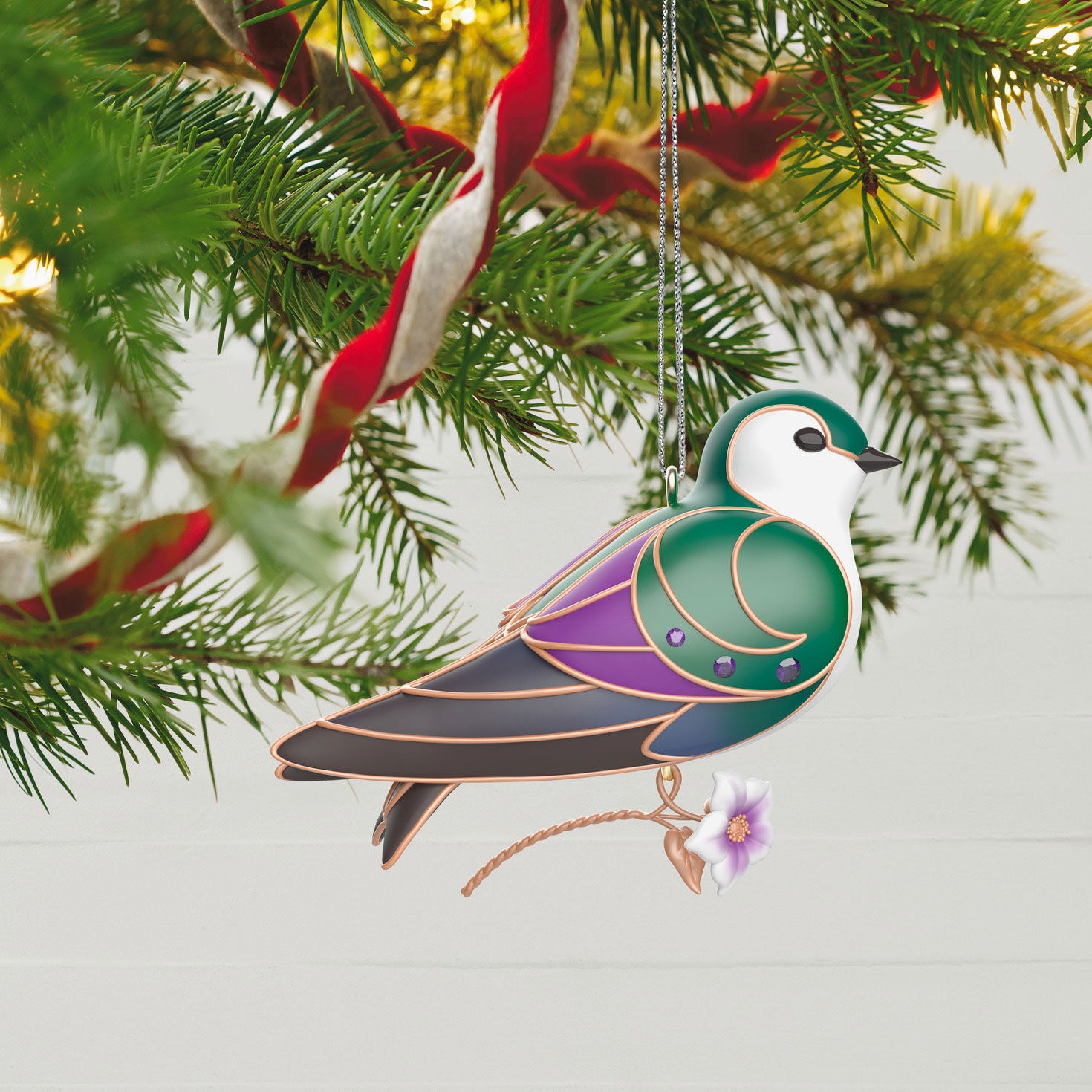 The Beauty of Birds, Violet-Green Swallow — Hallmark Keepsake Christmas Ornament hanging on a Christmas tree with vibrant colours and flower detail.