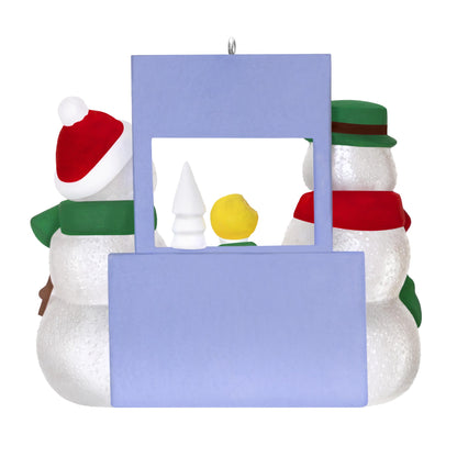 A Snowy Surprise — 2025 Hallmark Keepsake Christmas Ornament features a whimsical scene of three snowmen, with a blue backdrop.
