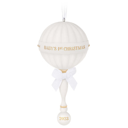 Baby's First Christmas (2023) Porcelain Rattle — Hallmark Keepsake Christmas Ornament, white with gold accents and a ribbon bow, hanging display.