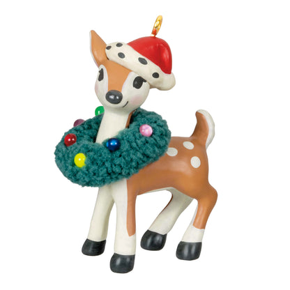 Retro Reindeer (Miniature) — Hallmark Keepsake Christmas Ornament in brown and white, wearing a Santa hat and colourful wreath, angled view.